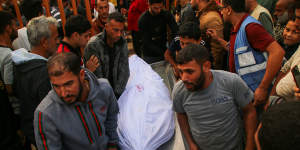 People mourn as they carry the body of a young Palestinian man on Sunday.