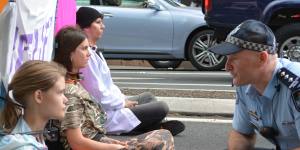 Extinction Rebellion protesters locked themselves to a barricade on the road in Brisbane's CBD on Wednesday morning.