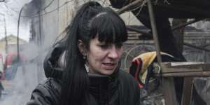 A woman walks past the debris in the aftermath of Russian shelling,in Mariupol,Ukraine.