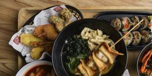 A platter with (clockwise from left) fried basket,fish cake udon soup,kim bab,bibim japchae,original chicken and tok bok ki. 