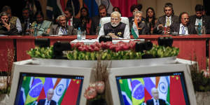 India’s Prime Minister Narendra Modi,centre,looks on at the plenary session as Russian President Vladimir Putin delivers his remarks via video link,at the 2023 BRICS Summit in Johannesburg.