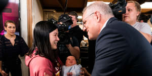 Prime Minister Scott Morrison greets Lisha Luo and her month-old baby Muxi at the Syndal Baptist Church in Melbourne.