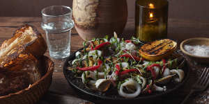 Squid ink paella with clams and calamari topped with green salsa and aioli.