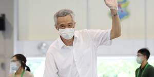 Singapore Prime Minister Lee Hsien Loong waves as he casts his vote on Friday.