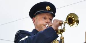 Bugler Jason Reeve plays the Last Post at the intersection of Flinders and Swanston streets on Wednesday.