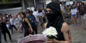 A woman carries a bowl with red ink symbolising the bloodshed that would come if Jair Bolsonaro,the presidential front-runner,were elected,during a protest against Bolsonaro,in Rio de Janiero.