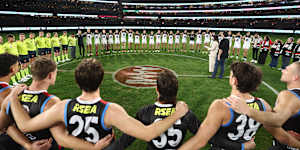 St Kilda,Carlton and the umpires link arms before Spud’s Game earlier this season.