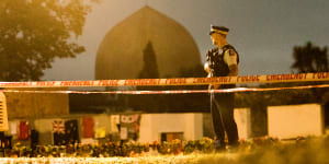 A policeman stands guard at the Al Noor Mosque early on Friday morning.