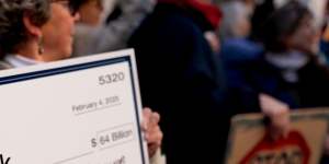 A demonstrator holds a fake cheque during a protest against Elon Musk outside the US Treasury building in Washington this week.