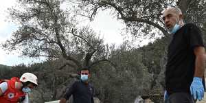 Villagers and the Red Cross sift through the rubble of a house flattened by an Israeli air strike in Aitou,Lebanon.