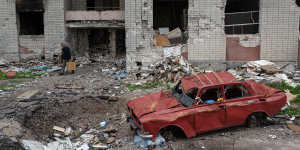 A man carries his belongings out of the heavily damaged apartment building in Chernihiv,north-east of Kyiv.