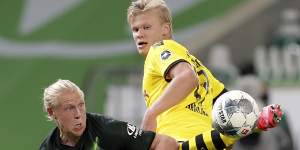 Wolfsburg's Xaver Schlager vies for the ball with Dortmund's Erling Haaland.