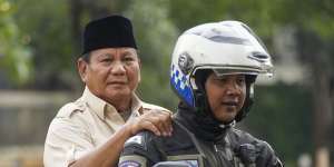 Prabowo Subianto (left) is taken to his father’s grave in Jakarta on Thursday.
