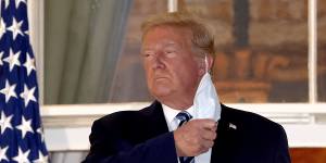 Trump takes off his mask on the balcony of the White House after contracting coronavirus.