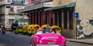 A vintage car passes Floridita restaurant in Old Havana.