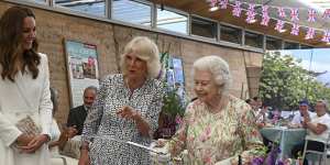 Camilla,the Duchess of Cornwall,and Kate,the Duchess of Cambridge,laugh as the Queen prepares to cut a cake with a sword at ‘The Big Lunch ’initiative,during the G7 summit in June.