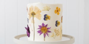 A custom cake decorated with edible flowers.