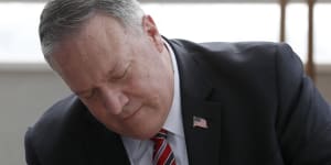 Former secretary of state Mike Pompeo using a pen.