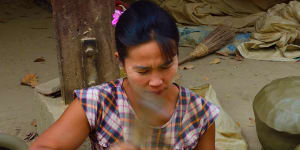 A woman beats clay waterpots into shape with a wooden paddle at Yandabo village near Mandalay.