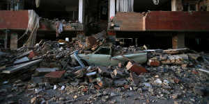 A car lays smashed by debris from the earthquake at the city of Sarpol-e-Zahab in western Iran on Monday.