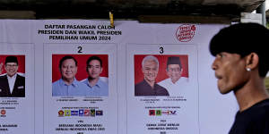 A man walks past a General Election Commission’s banner showing the presidential candidates,from left,Anies Baswedan and his running mate Muhaimin Iskandar,Prabowo Subianto and his running mate Gibran Rakabuming Raka,and Ganjar Pranowo and his running mate Mahfud MD in Jakarta.
