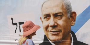 A pedestrian passes an election campaign billboard for Benjamin Netanyahu,Israel’s prime minister and the leader of the Likud party,in Tel Aviv,Israel.