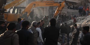 Emergency services work at a building hit by an air strike in Damascus blamed on Israel.