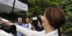 Photographer Sam Mooy,on assignment in Singapore in 2012,receives attention from then-Australian prime minister Julia Gillard,who mopped his brow.