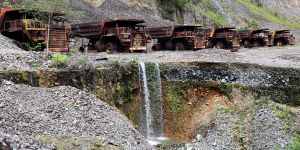 Heavy trucks sit rusting on the edges of Panguna copper mine,closed in 1989 as a result of sabotage.