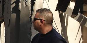 Police officers inspect the damage to a house hit by a rocket in Mishmeret,central Israel,on Monday.