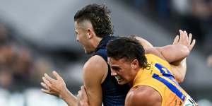 The Crows’ Jake Soligo gets caught holding the ball by West Coast’s Campbell Chesser.