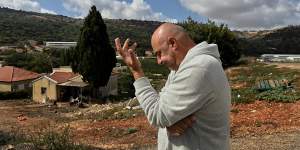 Chicken farmer Eytan Davidi at his farm in Margaliot on the border with Lebanon,which can be seen in the background.