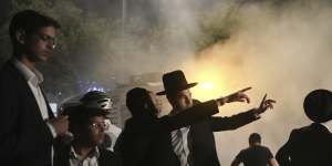 Ultra-Orthodox Jewish men inspect a road after it was hit by a rocket fired from the Gaza Strip,in the West Bank settlement of Beitar Illit this week.