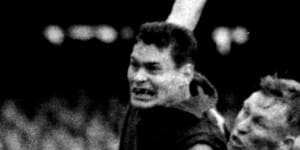 An iconic image of Ron Barassi kicking a brilliant goal while being tackled by Essendon’s Bob Suter in 1957.