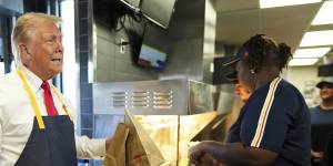 Donald Trump holds an order near the drive-thru window during a visit to McDonald’s.