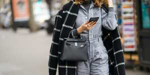 PARIS,FRANCE - FEBRUARY 28:A guest wears a black and white checked pattern plaid long coat,a Hermes bag,a denim jumpsuit,a turtleneck top,outside Ralph&Russo,during Paris Fashion Week - Womenswear Fall/Winter 2020/2021,on February 28,2020 in Paris,France. (Photo by Edward Berthelot/Getty Images) Get the look:back to the office