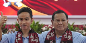 Presidential candidate Prabowo Subianto (right) and his running mate Gibran Rakabuming Raka,the eldest son of President Joko Widodo,wave at the media after registering their candidacy in Jakarta on Wednesday.
