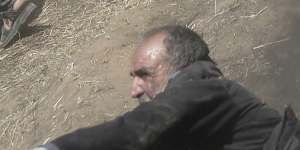 An elderly Palestinian man falls on the ground after being shot by Israeli troops.