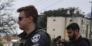 Israeli security forces examine the site hit by a rocket fired from Lebanon,in Kiryat Shmona.