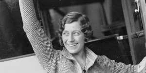 English aviatrix Amy Johnson waving and opening the door to her plane,Sydney,May 1930 