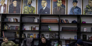 A civilian volunteer waits with his gun at a territorial defence unit registration office.