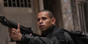 A police officer aims his weapon during a police operation against organised crime in the Mare Complex of Rio de Janeiro on October 9.
