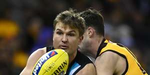 Port Adelaide’s Ollie Wines handballs while being tackled.