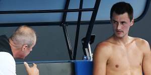 John Tomic talks to his son during the 2018 Australian Open.