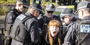 A woman is arrested in Fishermans Bend after being disconnected from a fellow protester by police.