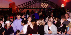Crowds at the Sydney Opera House watch the Olympic Rings light up the Sydney Harbour Bridge. 