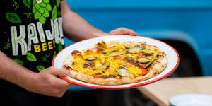 Cheeseburger pizza topped with San Marzano tomatoes,American cheese,red onion,beef mince,pickles and mustard.
