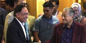 Malaysian Prime Minister Mahathir Mohamad shakes hand with his then-designated successor Anwar Ibrahim at the weekend.