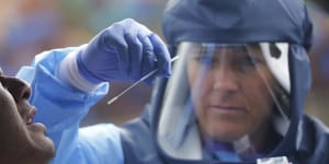 Salt Lake County Health Department public health nurse Lee Cherie Booth performs a coronavirus test outside the Salt Lake County Health Department in Salt Lake City. 