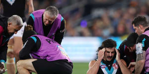 Port Adelaide teammates Aliir Aliir and Lachie Jones are treated after they collided in Saturday night’s game.